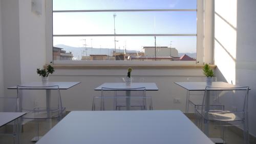 a room with tables and chairs and a large window at Domus Nova in Reggio Calabria