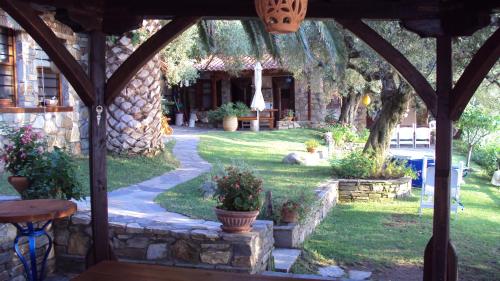 a garden with a stone building and a table and a pathway at Mare Nostrum in Neos Marmaras