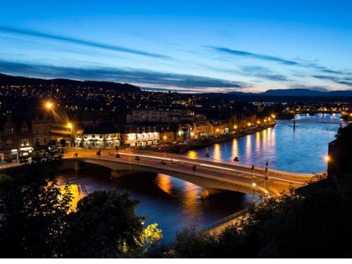 a bridge over a river in a city at night at Crown Apartment in Inverness