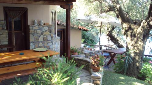 a patio with a wooden table and an umbrella at Mare Nostrum in Neos Marmaras