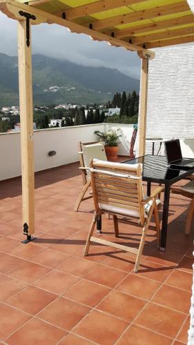 a patio with a table and a bench on a roof at Green Oasis in Lámira