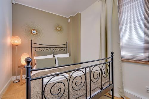 a bedroom with a bed with a wrought iron railing at Lion Apartments MEWA in Sopot