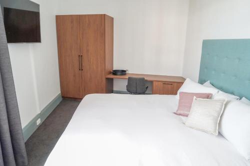 a bedroom with a large white bed with two pillows at Oasis on Beamish Hotel in Sydney
