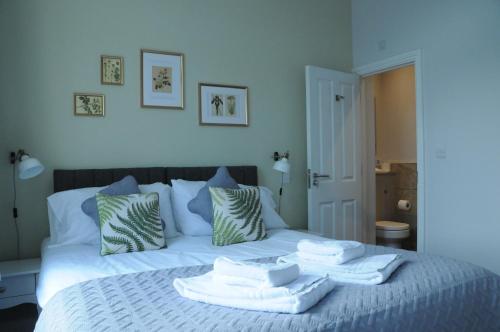 a bedroom with a bed with towels on it at The Milford Arms in Hounslow