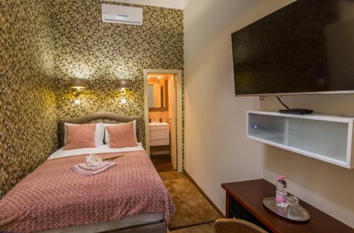 a small bedroom with a bed and a television at Dob Twenty Rooms in Budapest