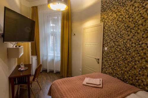 a bedroom with a bed and a television and a table at Dob Twenty Rooms in Budapest