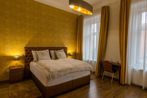 a bedroom with a bed with yellow walls and windows at Dob Twenty Rooms in Budapest