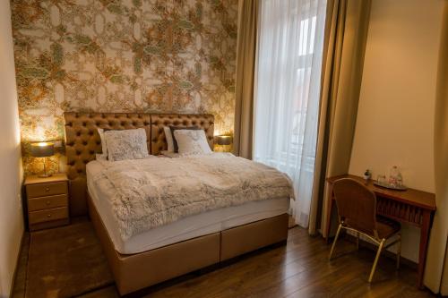 a bedroom with a bed and a desk and a window at Dob Twenty Rooms in Budapest