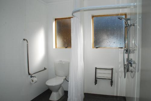 a bathroom with a toilet and a window at Aquarius Motel in Ohope Beach