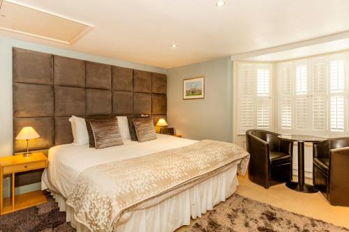 a bedroom with a large bed and a table and chairs at Brightonwave in Brighton & Hove