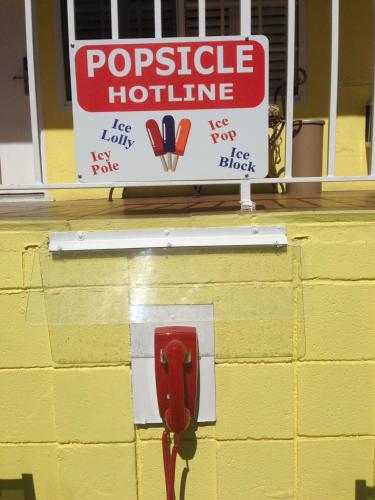 a sign on a yellow wall with a red parking meter at Magic Castle Hotel in Los Angeles