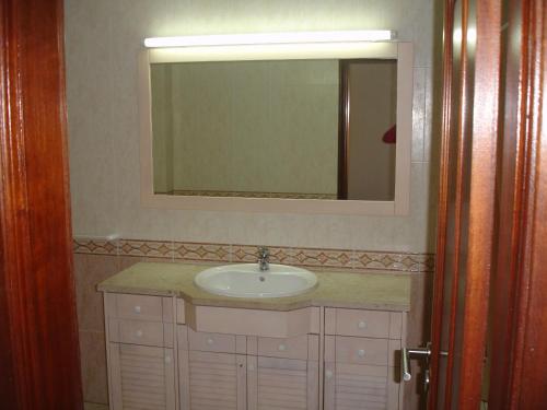 un baño con lavabo y espejo en Vila Marachique lt 6 107, en Alvor