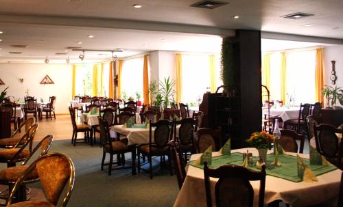 a dining room with many tables and chairs and tablesearcher at Hotel Heidekrug in Grünplan
