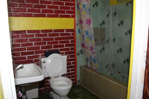 a bathroom with a toilet and a shower at Hotel Casa Del Viajero in Quetzaltenango
