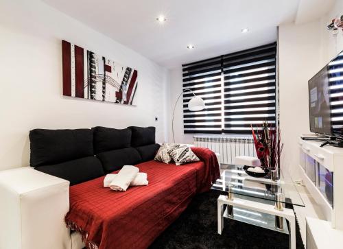 - une chambre avec un canapé et une couverture rouge dans l'établissement Rent Apartment-Flat Salamanca, à Salamanque