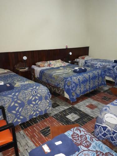 a room with three beds sitting next to each other at Hotel Casa Del Viajero in Quetzaltenango