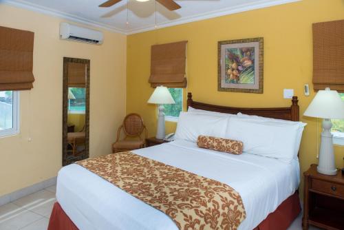 a bedroom with a large bed with a pillow on it at Yellow Bird Hotel in Christ Church