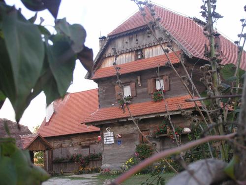 an old wooden house with a red roof at Tradicije Cigoc in Čigoč