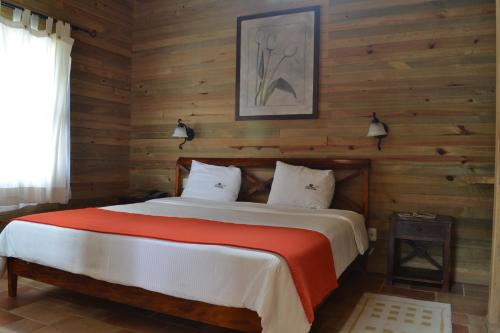 a bedroom with a bed in a wooden wall at Finca Hamburgo La Ruta del Cafe in Tapachula