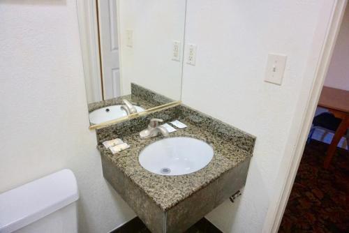 W łazience znajduje się umywalka i lustro. w obiekcie Satellite Motel, Los Angeles - LAX w mieście South Los Angeles