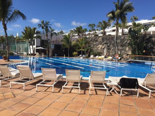 een groep stoelen naast een zwembad bij Apartamento Ricardo in Puerto del Carmen