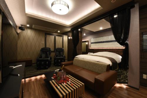 um quarto com uma cama e um sofá em Hotel Star Resort Hers (Adult Only) em Sagamihara