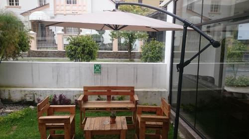 a table and chairs with an umbrella on a patio at Hotel + Arte in Quito