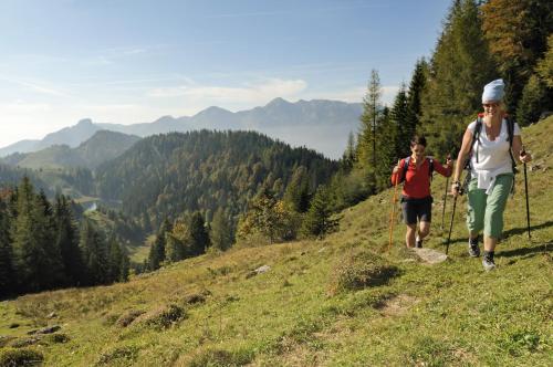 two people walking up a hill on a trail at Landhaus Lenzenhof in Reit im Winkl