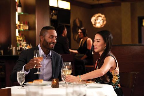 a man and a woman sitting at a table with wine glasses at Mount Airy Casino Resort - Adults Only 21 Plus in Mount Pocono