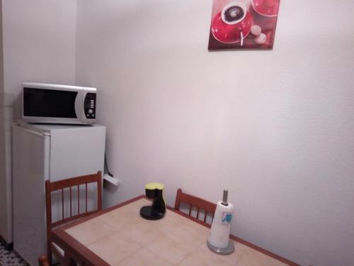 a small kitchen with a table and a microwave at Appartement 3 pièces in Saint-Louis