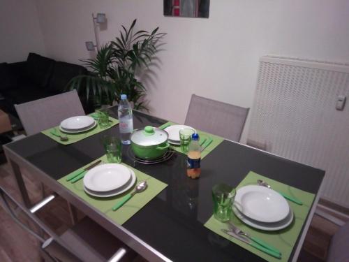 a dining table with plates and dishes on it at Appartement 3 pièces in Saint-Louis