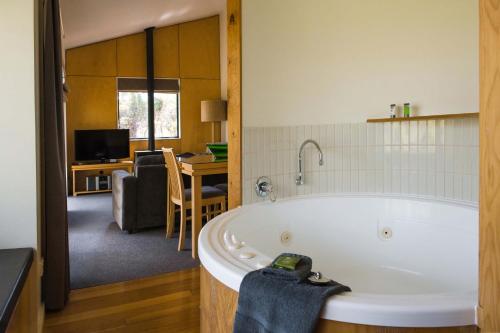 un bagno con vasca e un soggiorno. di Cradle Mountain Wilderness Village a Cradle Mountain