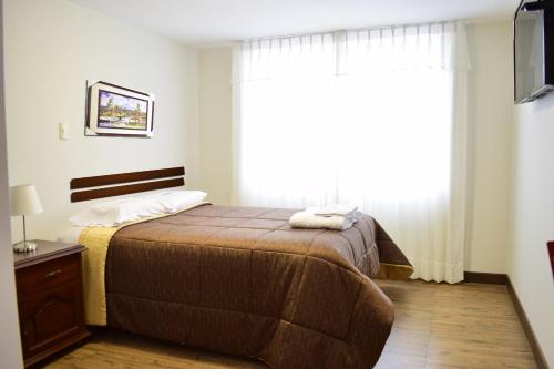 a bedroom with a bed and a large window at Posada La Merced in Arequipa