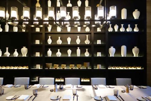 a dining room with a table and a display of vases at Cheery Dragon Canal Hotel Hangzhou - Intangible Cultural Heritage Hotel in Hangzhou