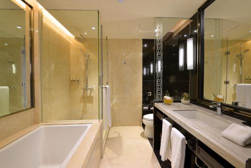 a bathroom with a tub and a shower and a sink at Fuzhou Lakeside Hotel in Fuzhou