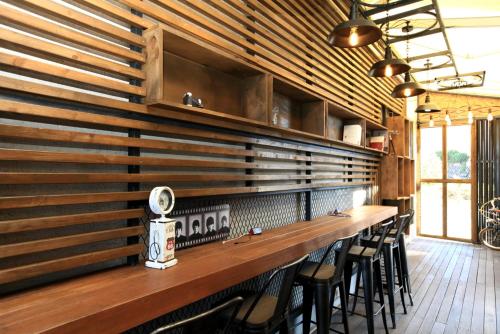 a bar with wooden walls and stools in a restaurant at Farms Village in Jeju