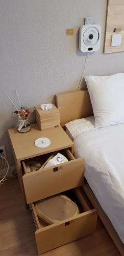 a room with a bed and a table next to a bed at Farms Village in Jeju