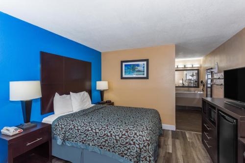 a hotel room with a bed and a bathroom at Days Inn by Wyndham Sarasota Bay in Sarasota