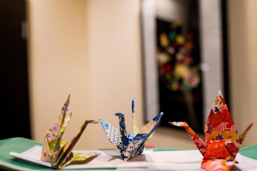 a group of origami butterflies sitting on a table at KYOTO Kazenoya Sara in Kyoto