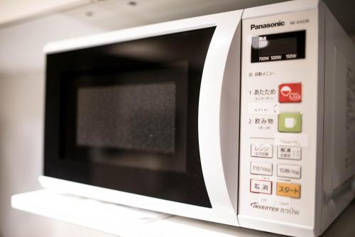 a white microwave oven sitting on top of a counter at KYOTO Kazenoya Sara in Kyoto