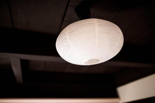 a white light fixture hanging from a ceiling at KYOTO Kazenoya Sara in Kyoto