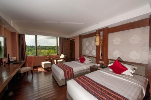a hotel room with two beds and a desk at Rose Garden Hotel in Yangon