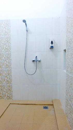 a shower in a bathroom with a tile floor at City Stay Homestay Jogja in Yogyakarta