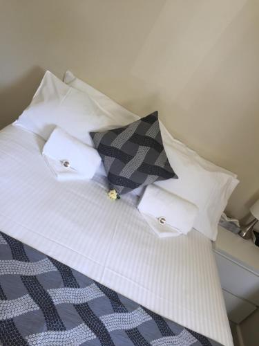 a white bed with a white blanket and a white pillow at Narimba Motel in Port Macquarie
