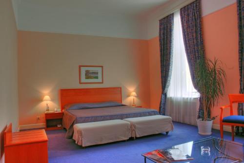 a bedroom with a bed and a glass table at Grand Hotel Ukraine in Dnipro
