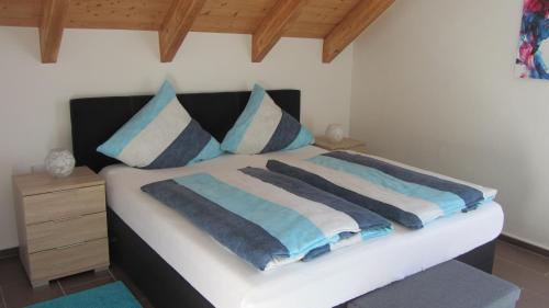 a bedroom with a bed with blue and white pillows at Ferienwohnung Am Alten Forsthaus Neuenbau in Neuenbau