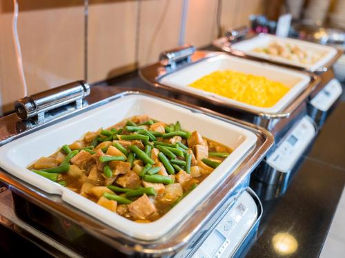 a buffet with two trays of food on a counter at Super Hotel Yokkaichi Route 1 in Yokkaichi