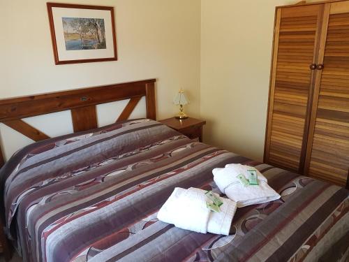 a bedroom with a bed with towels on it at Windana Cottages in Hawker