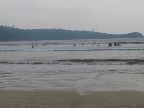 a group of people in the water at the beach at Apna Homestay Apartments in Unawatuna
