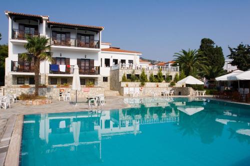 a hotel with a swimming pool in front of a building at Dionyssos in Skopelos Town